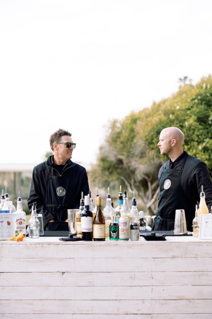 pouring drinks at seaside wedding