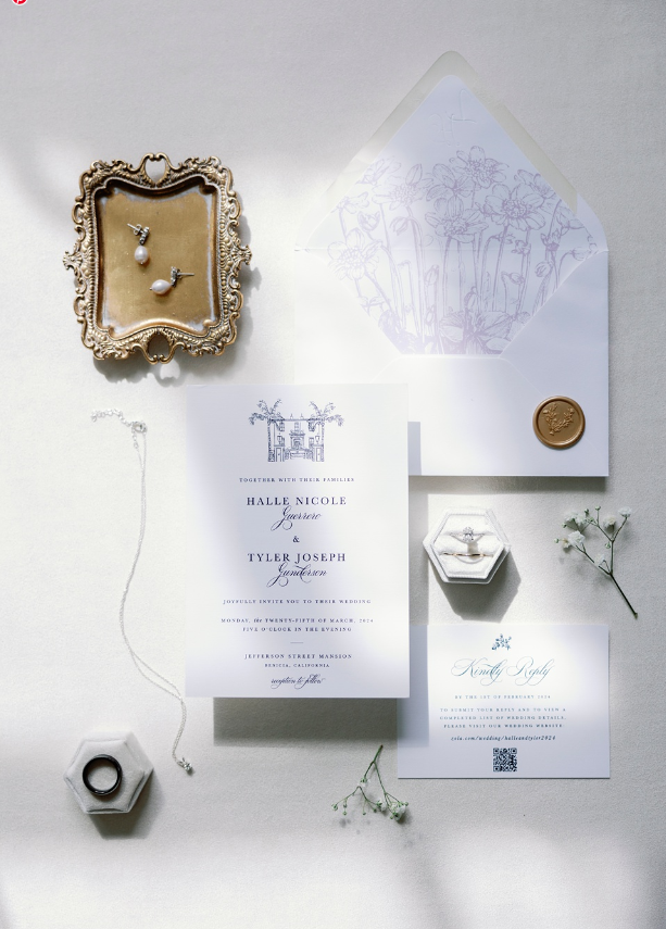 flat lay of white and black wedding invitation with custom envelope, bridal earrings and wedding bands