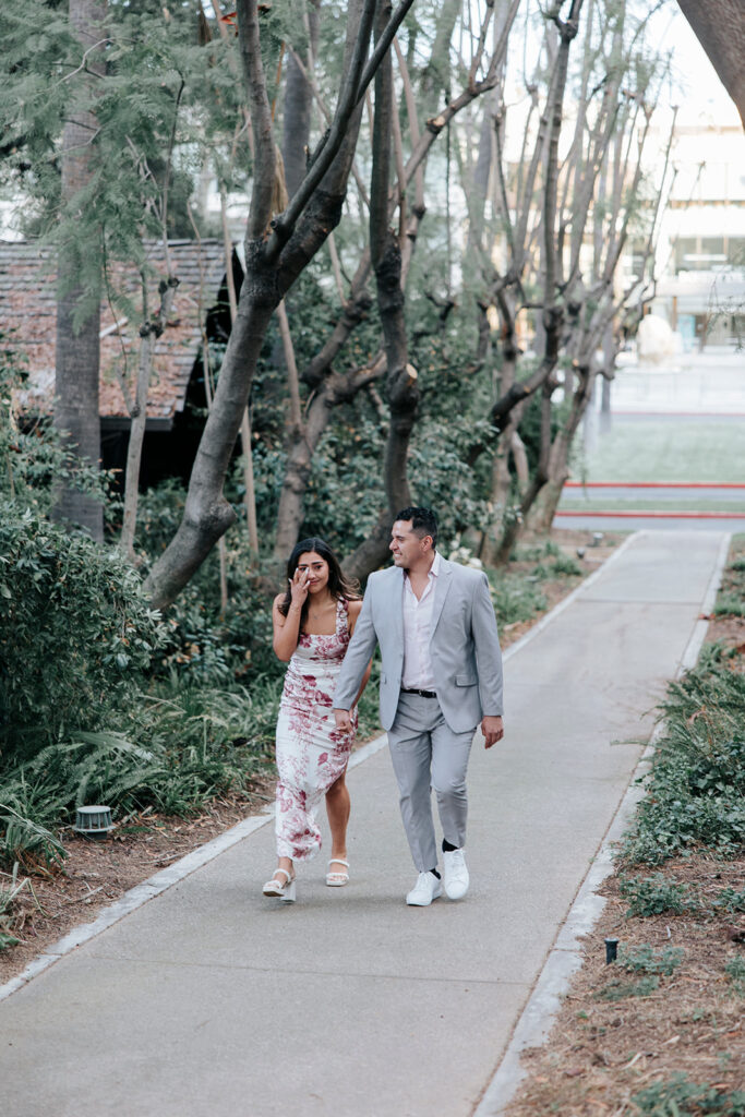 Man and woman walk toward surprise proposal at Pasadena History of Museum.