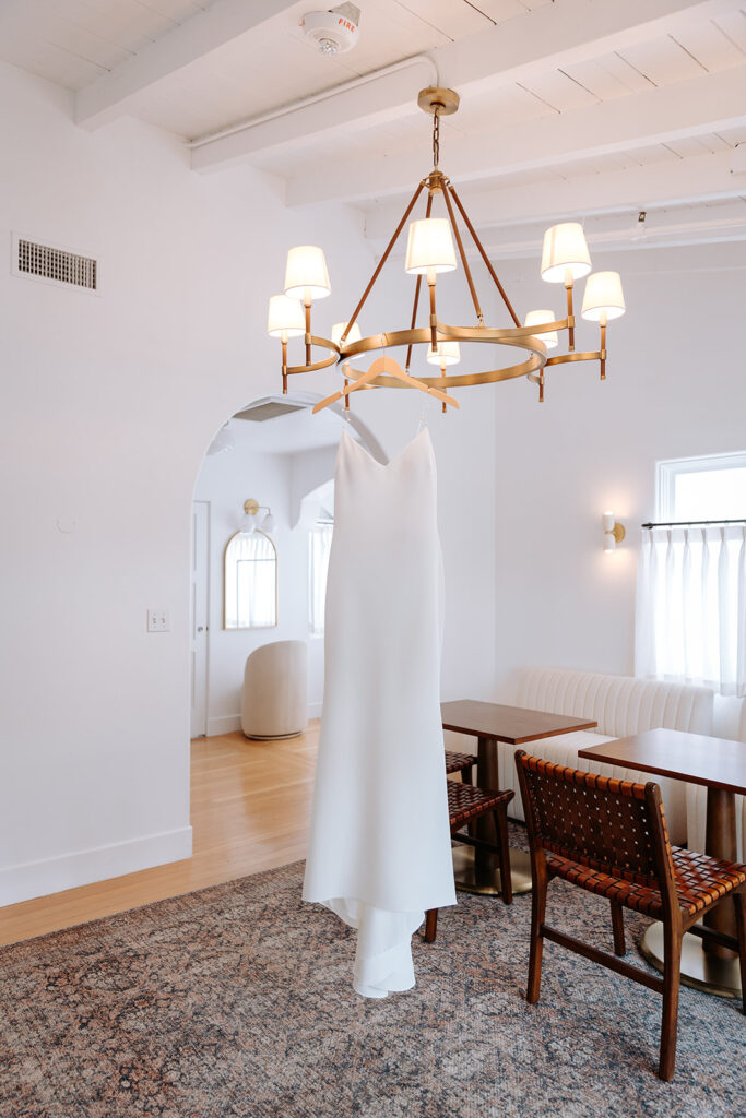 wedding dress hanging on chandelier