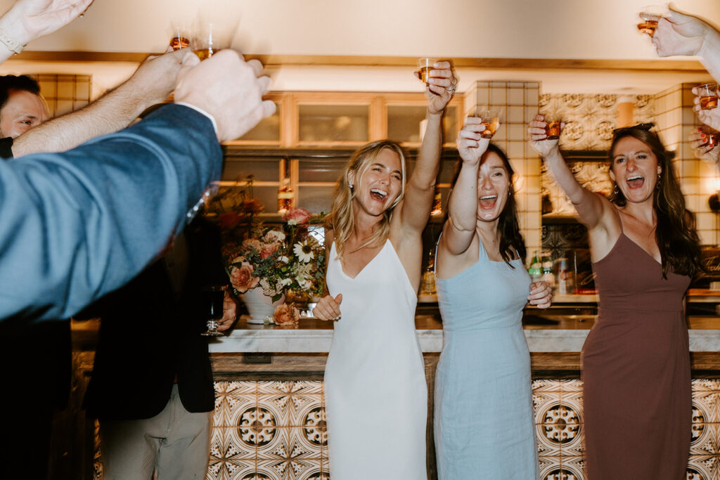 bride with guests toasting in the air celebrating