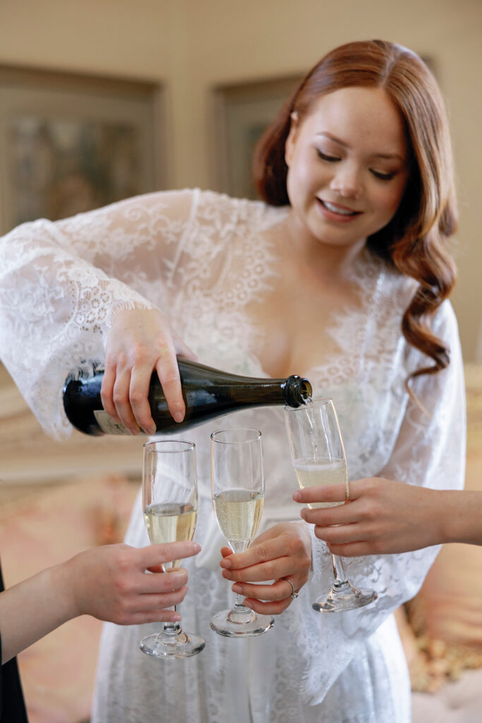 bride pouring champagne for bridesmaids and herself