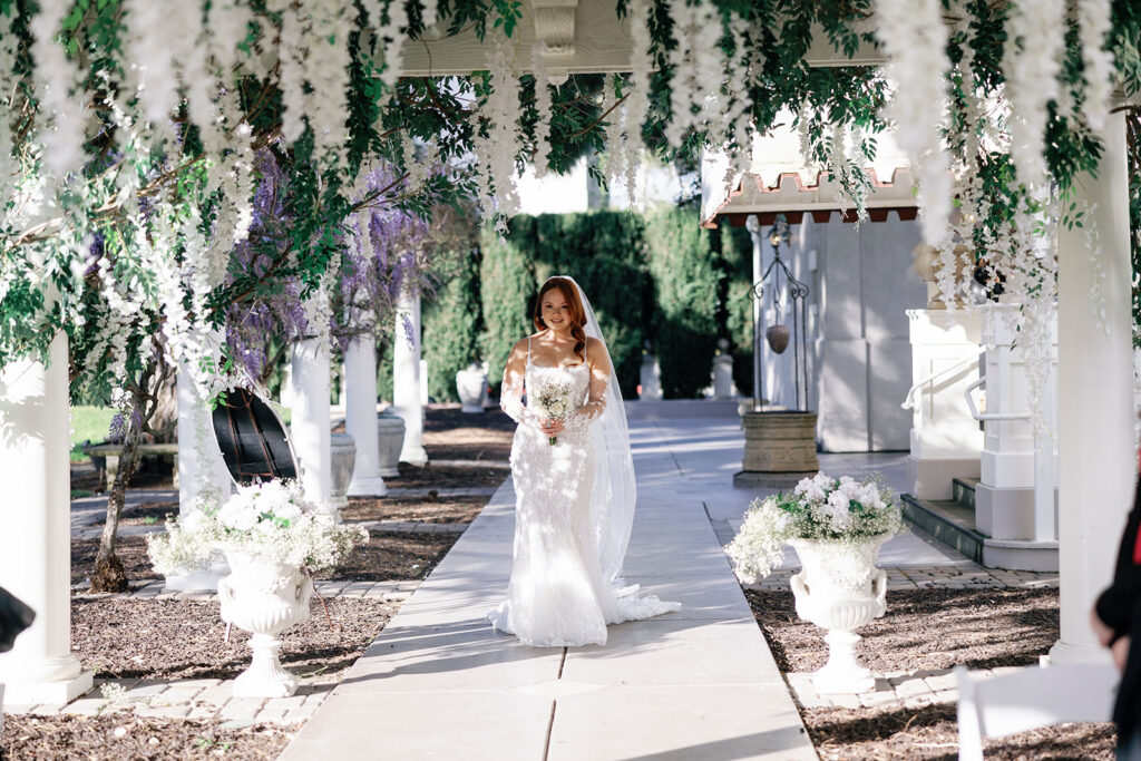 bride coming down the aisle for garden inspired wedding ceremony 