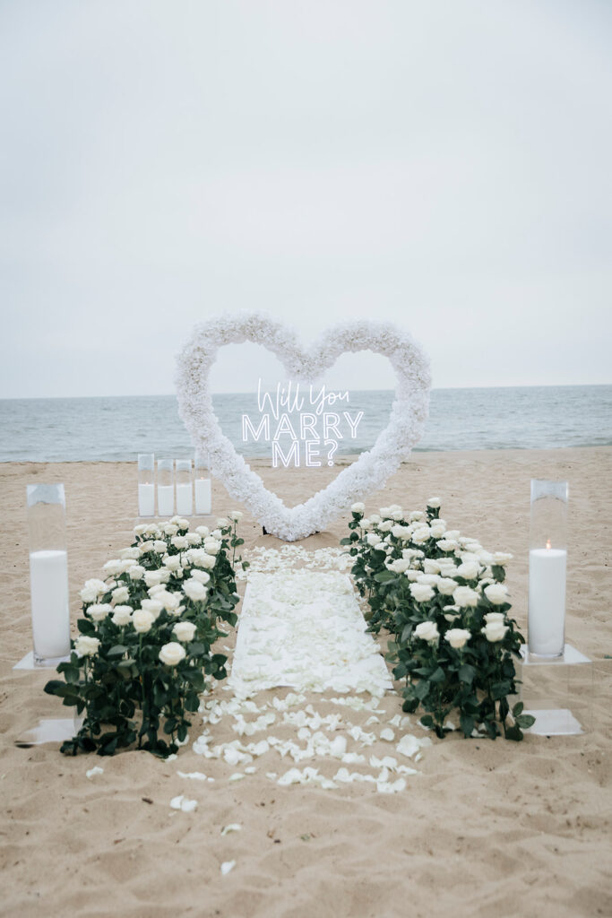 White heart-shaped rose floral installment on Orange County beach for proposal. 