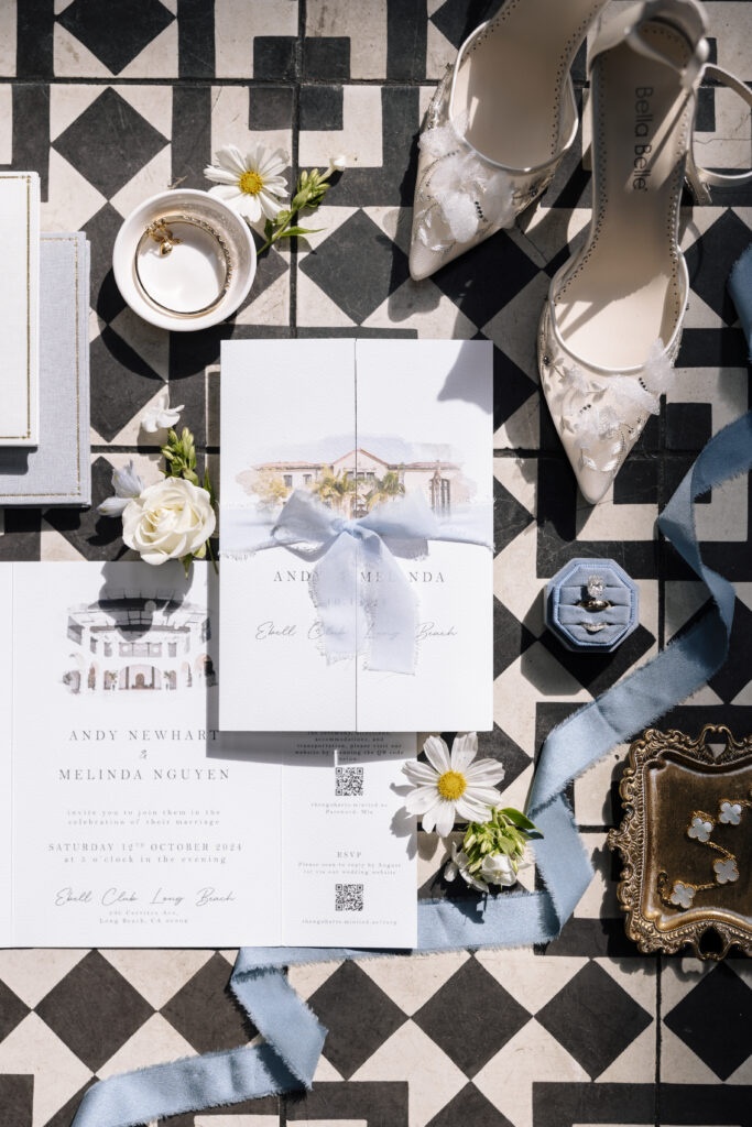 modern wedding stationery flat lay shot with various wedding accessories like bridal shoes, rings, florals.