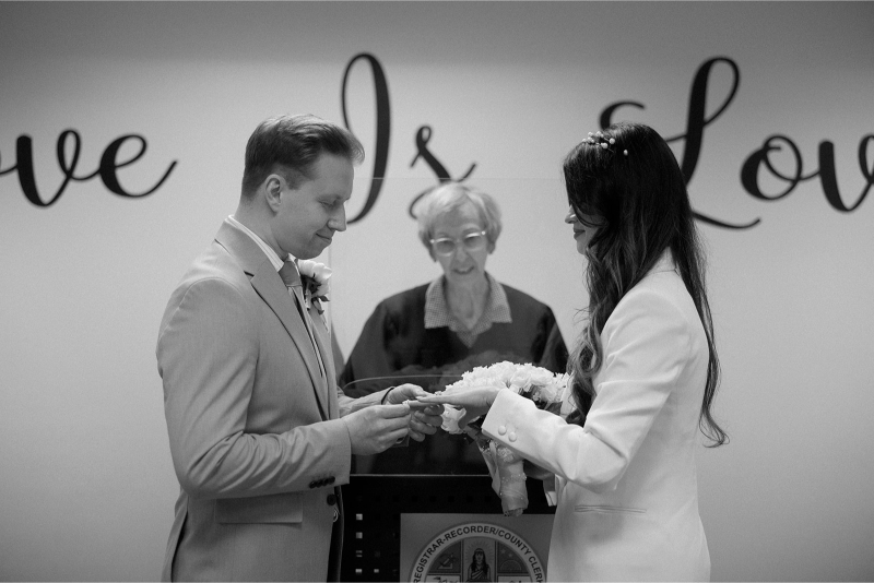 A bride and groom exchange rings during an intimate ceremony inside the Beverly Hills Courthouse.