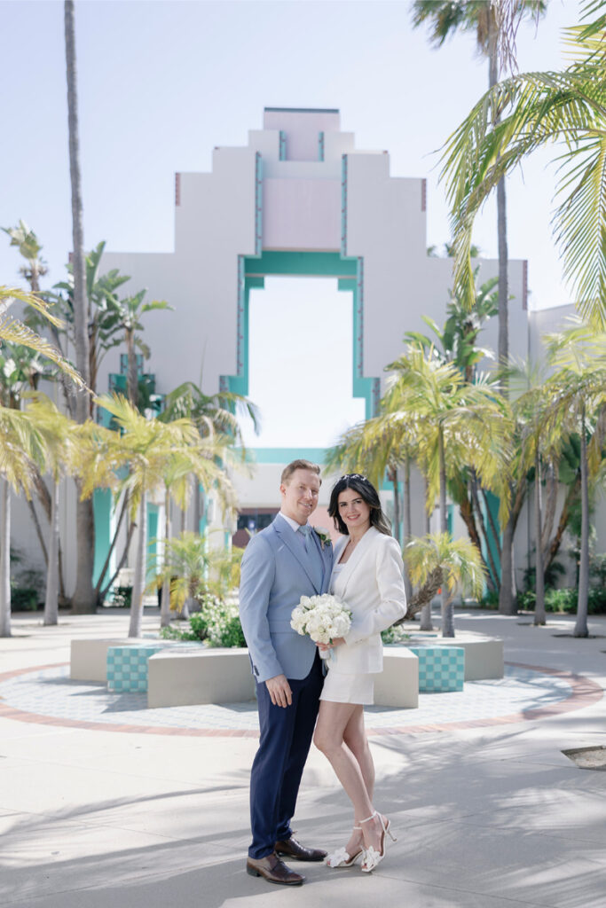 The couple poses outside a stunning architectural backdrop, a perfect moment from their city hall elopement in Orange County.