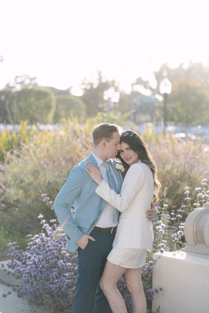 Bathed in soft sunlight, the bride and groom pose amidst blooming lavender, marking their city hall elopement in Orange County.