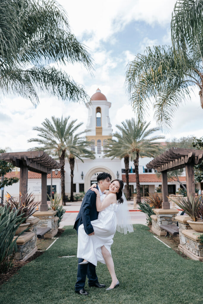 Bride and groom hug during elopement in front of Laguna Hills Civic Center. 