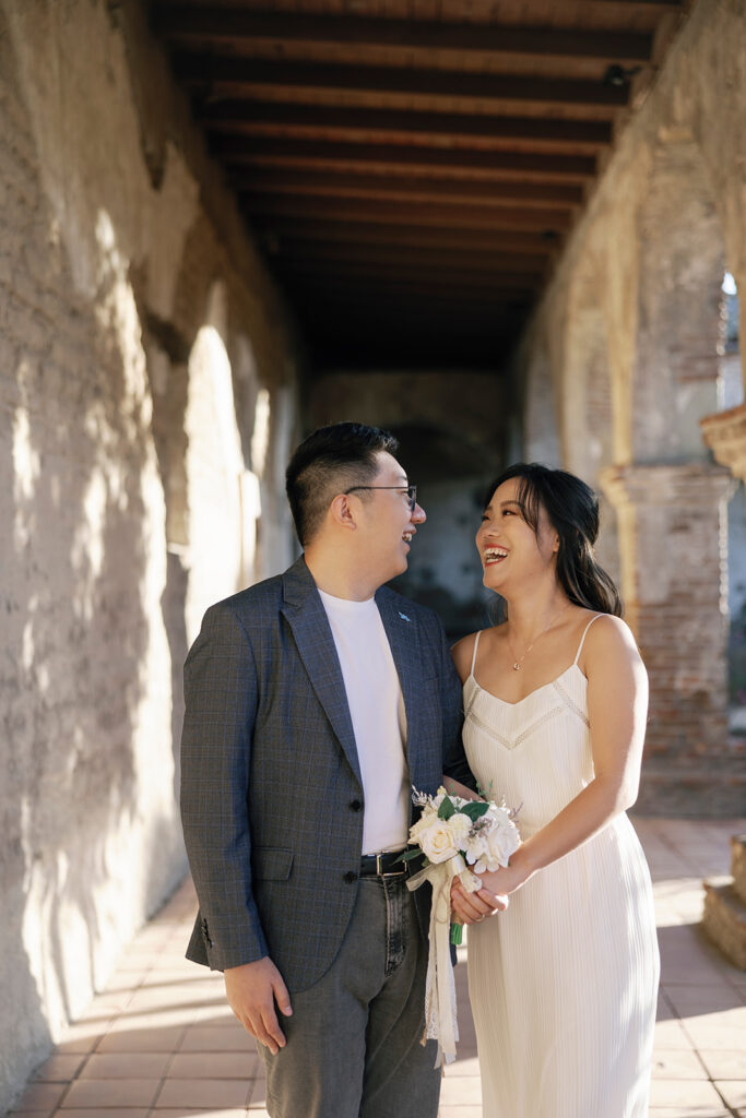 A couple smiling joyfully, celebrating being newly engaged in Orange County.