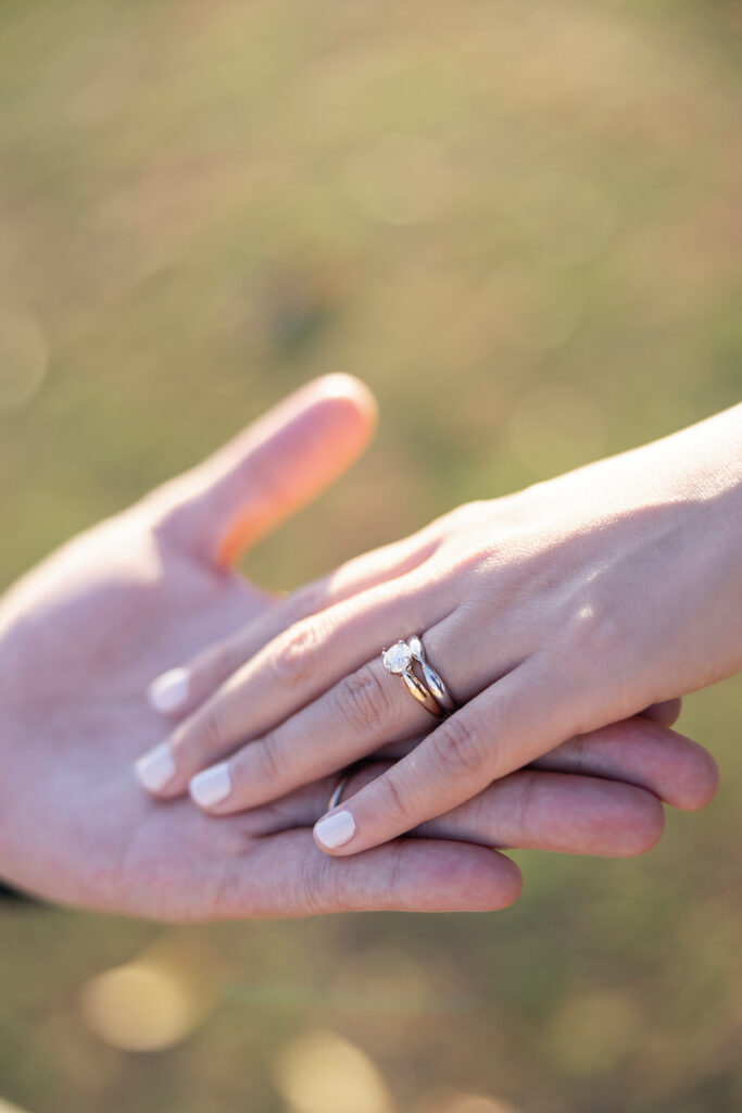 A romantic close-up of an engagement ring as the couple hold hands.