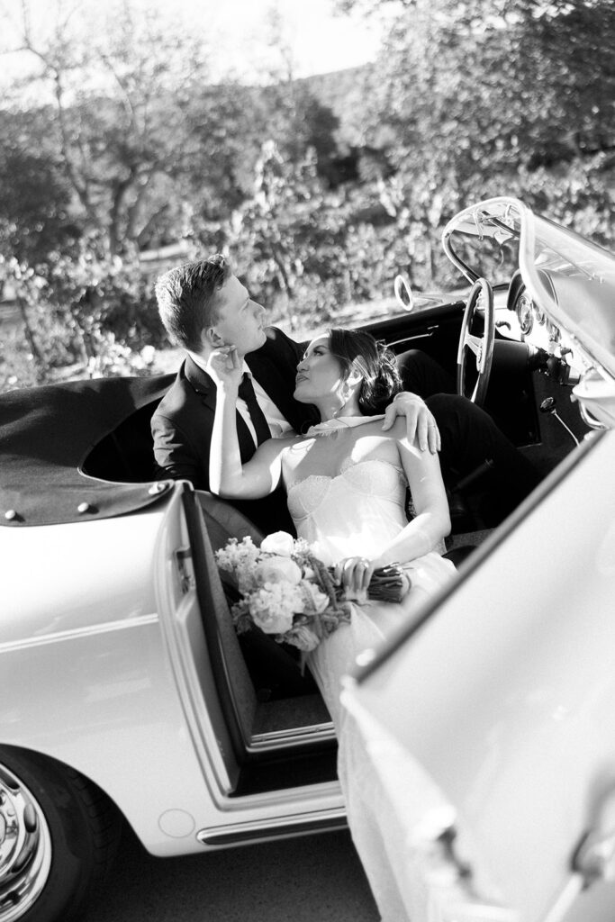 A couple sharing an intimate moment in a vintage car, a perfect addition to their photos of getting engaged in Orange County.