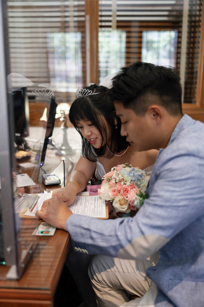 Bride and groom sign marriage license during city hall elopement in Orange County. 