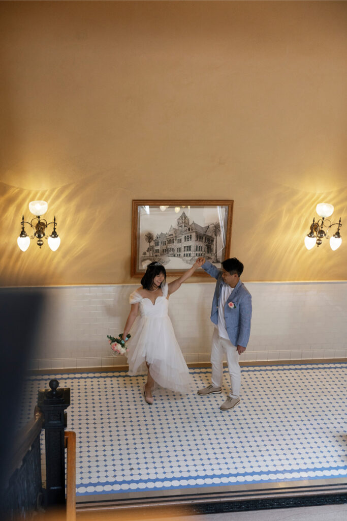 Groom spins bride in Old Orange County Courthouse. 