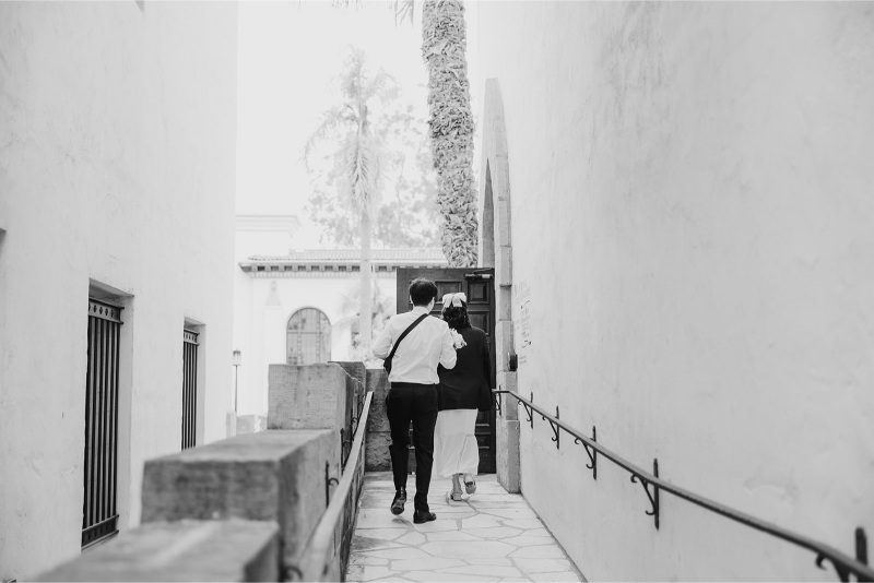 Black and white photo of bride and groom before they enter Santa Barbara Courthouse for their elopement. 