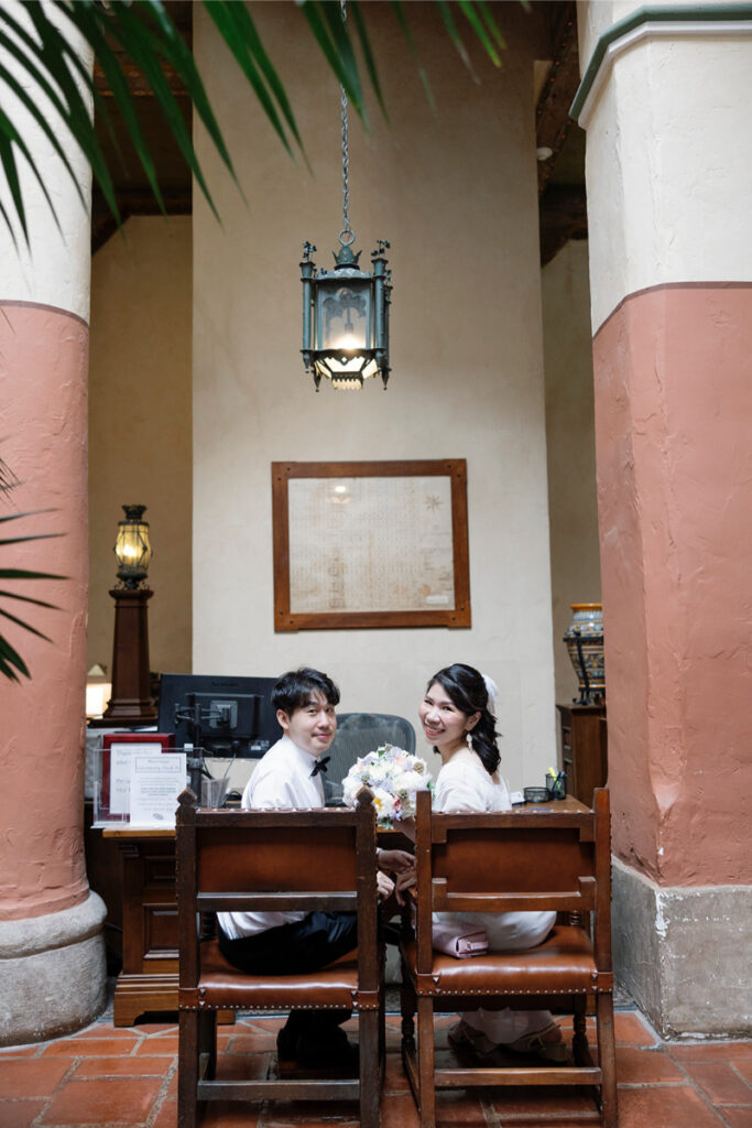 Bride and groom turn around to face photographer during their elopement at Santa Barbara Courthouse. 